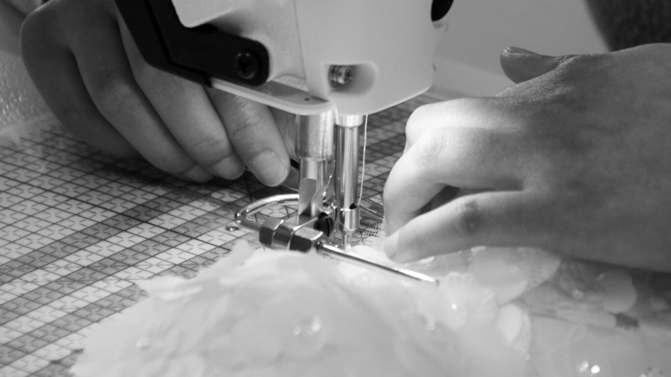 Tissu délicatement assemblé sous une machine à coudre pour une création sur-mesure.