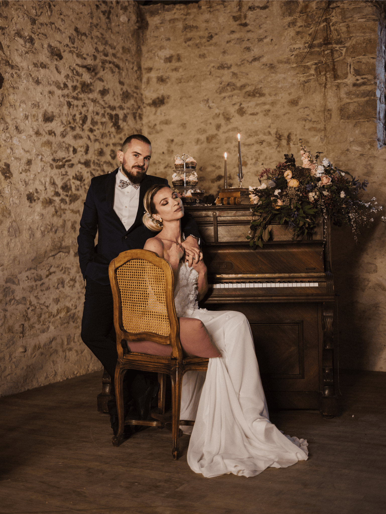Un couple de mariés pris en photo devant un piano, entouré de décoration inspirée de la musique, créant une atmosphère romantique et harmonieuse.