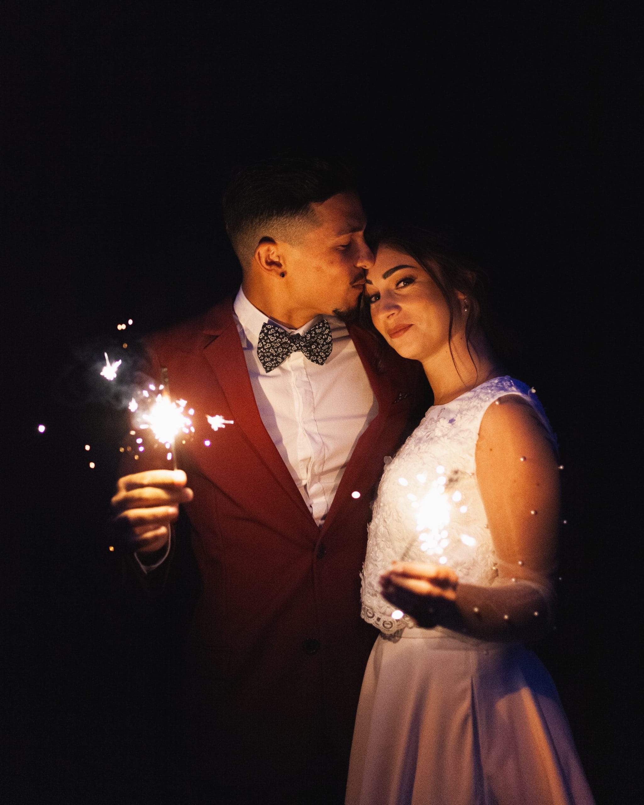 Un couple de mariés en soirée entouré de bougies scintillantes, créant une ambiance romantique et magique pour célébrer leur union.