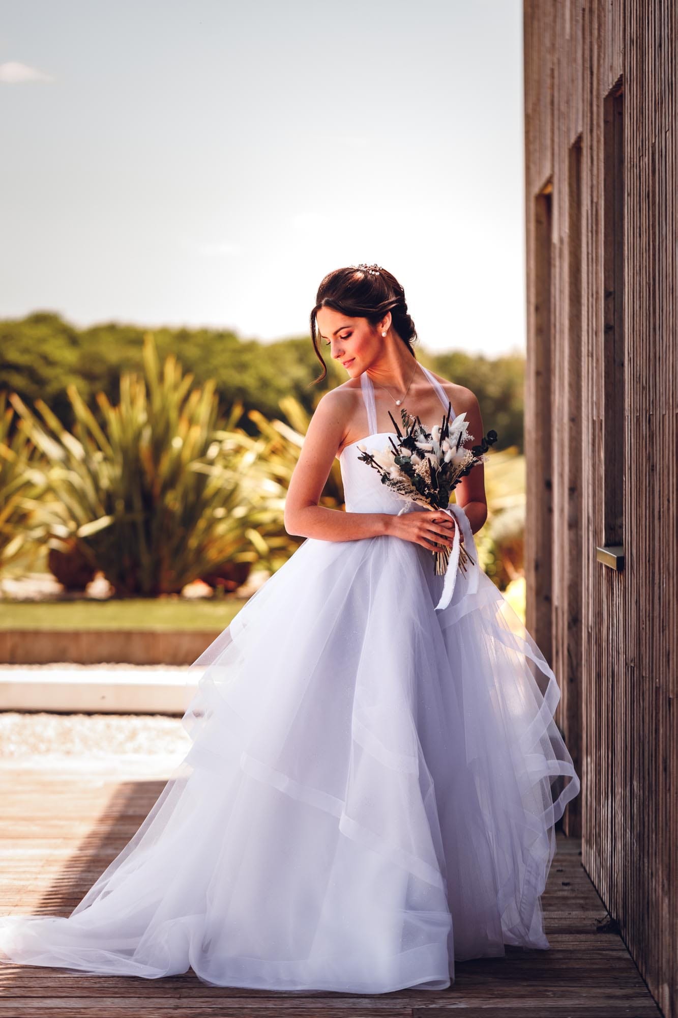 Robe de mariée en tulle scintillant ornée de volants, alliant élégance et légèreté pour un look féérique et raffiné.