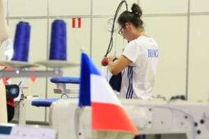 Yane-Nirina concentrée pendant la compétition WorldSkills, démontrant son expertise en couture sur-mesure et sa maîtrise technique
