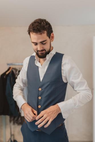 Ce gilet bleu, orné de boutons en bois, crée une silhouette chic et originale, avec un détail authentique et raffiné.
