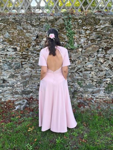 Une robe cocktail rose élégante, offrant une silhouette féminine et raffinée, idéale pour toute occasion spéciale.