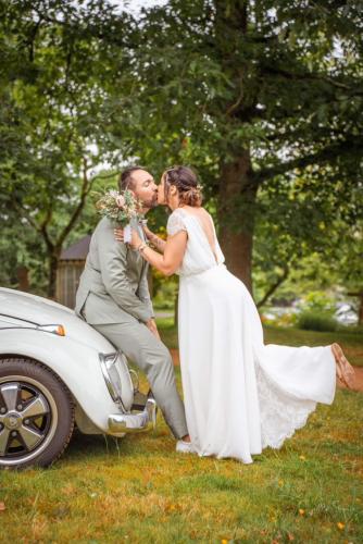 Robe de mariée en mousseline avec un détail de dentelle pour les manche et une quille dans le dos.
