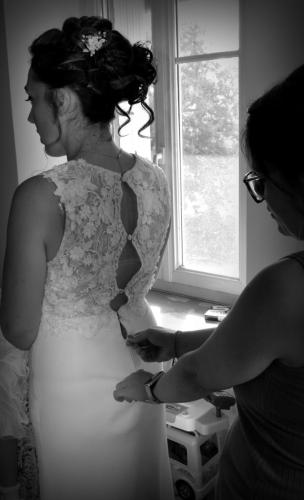 Le dos de cette robe de mariée, délicatement orné de dentelle retravaillée, se ferme avec des boutons recouverts, ajoutant une touche de raffinement et de sophistication.