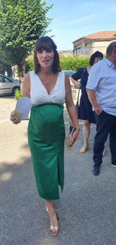 Une robe cocktail moulante pour femme enceinte, combinant un haut blanc élégant et un bas vert fluide, mettant en valeur la silhouette tout en offrant confort et style.